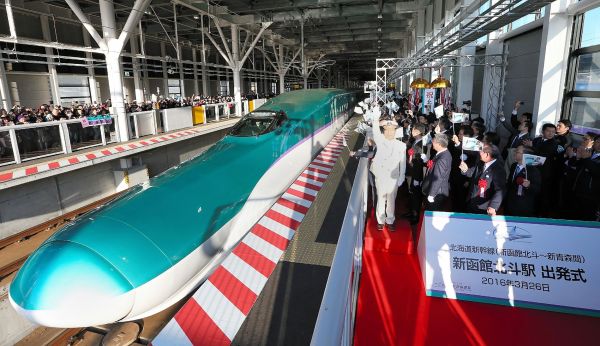 资料图片:2016年3月26日,在日本北海道的新函馆北斗站举行的通车仪式上,人们庆祝首列从北海道开往东京的新干线列车启程。新华社/法新